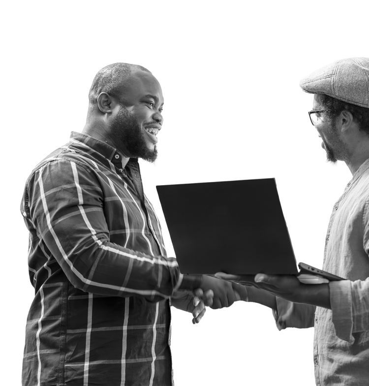 Two men shaking hands while one of them holds a laptop