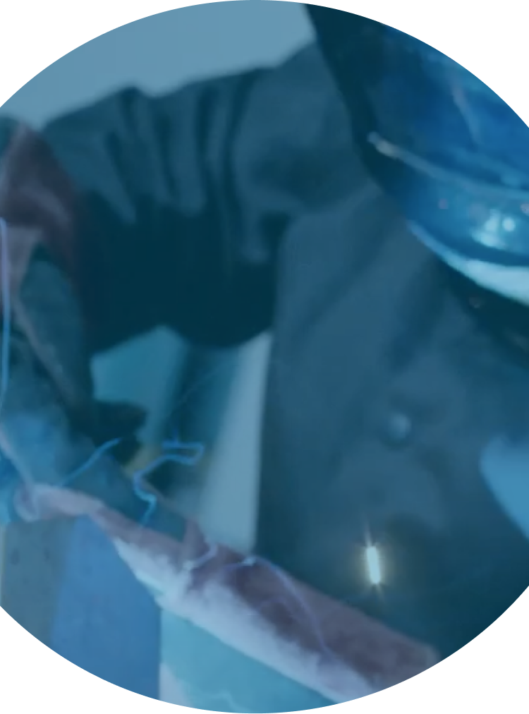 a person in a welding mask wearing protective gloves