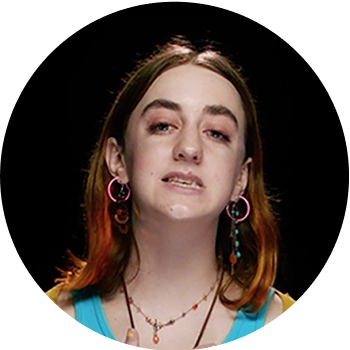 young, bejeweled white woman with pink hair performing poetry
